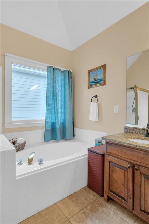 2810 Olde Town Park Dr, Norcross, GA 30071 - full bathroom with a shower with shower door, tile patterned floors, a bath, vanity, and lofted ceiling
