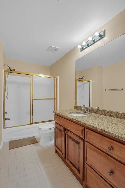 2810 Olde Town Park Dr, Norcross, GA 30071 - bathroom featuring vanity, toilet, visible vents, enclosed tub / shower combo, and tile patterned flooring