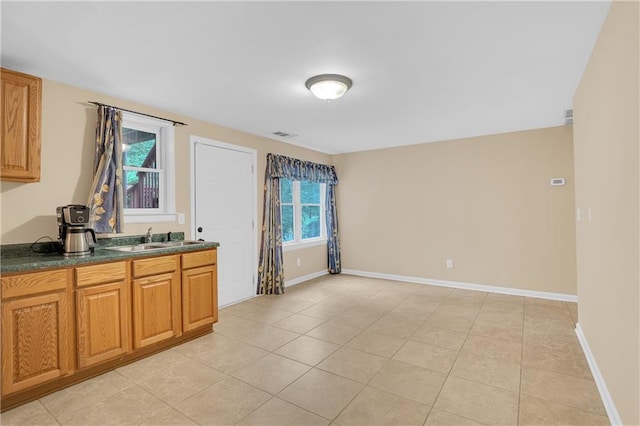 2810 Olde Town Park Dr, Norcross, GA 30071 - kitchen with light tile patterned floors, brown cabinets, a sink, dark countertops, and baseboards