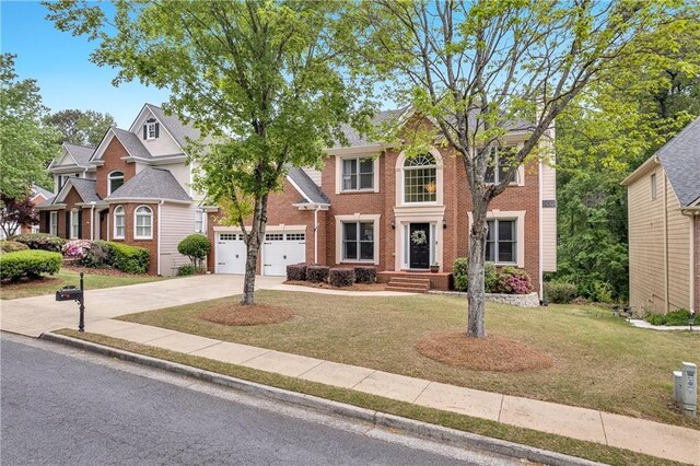 2810 Olde Town Park Dr, Norcross, GA 30071 - view of front of house with driveway, a front yard, brick siding, and a garage