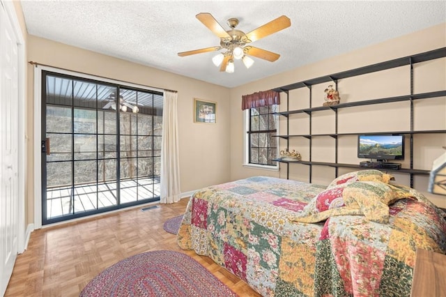 bedroom featuring access to exterior, visible vents, a textured ceiling, and baseboards