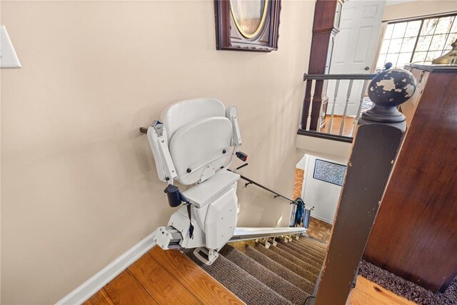 staircase featuring baseboards and wood finished floors