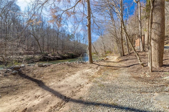 exterior space featuring a water view and a wooded view