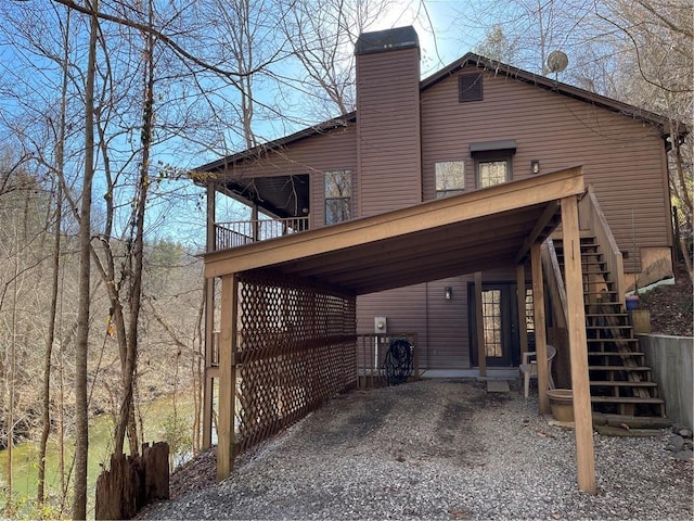 view of side of home featuring stairway and a chimney