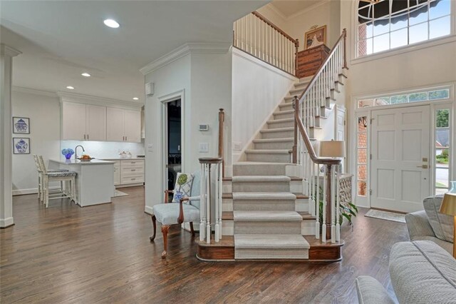 entrance foyer featuring dark wood-type flooring and ornamental molding