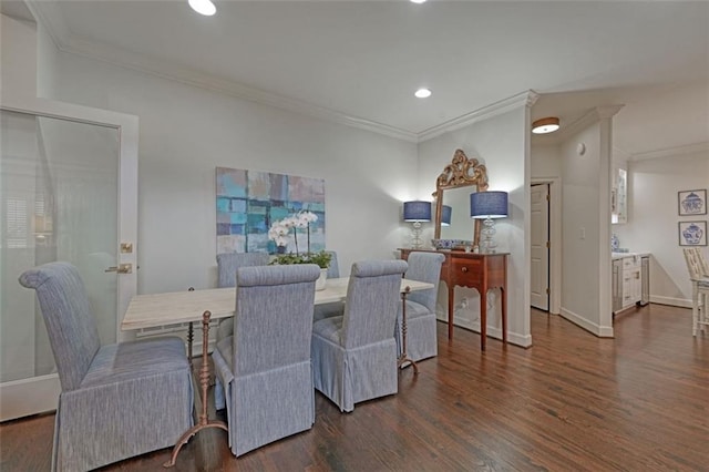 dining space with dark hardwood / wood-style flooring and crown molding