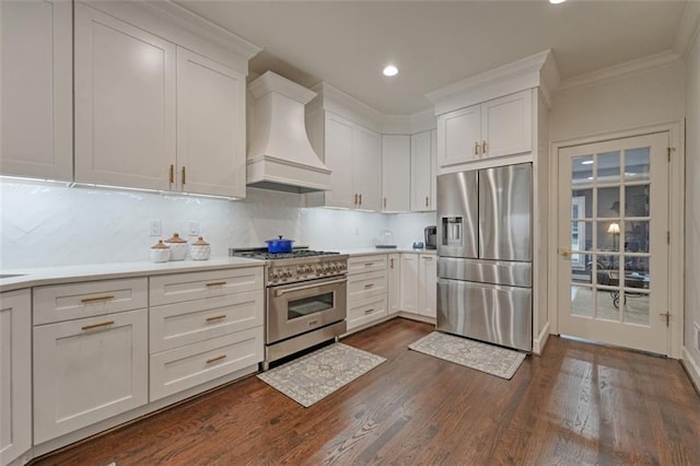 kitchen with appliances with stainless steel finishes, premium range hood, and white cabinets