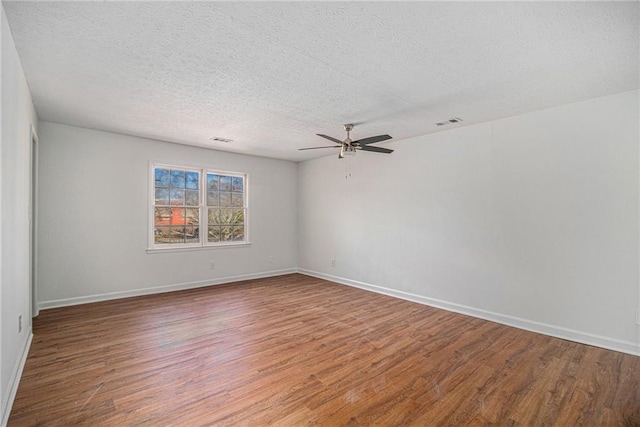 spare room featuring a ceiling fan, a textured ceiling, visible vents, and wood finished floors