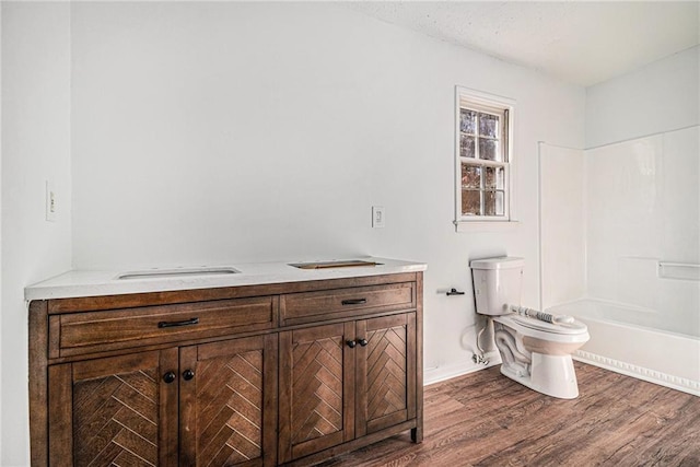 full bath with toilet, shower / bath combination, wood finished floors, and vanity