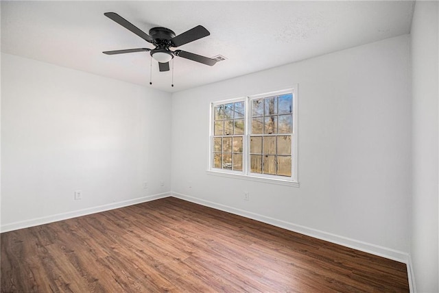 spare room featuring ceiling fan, baseboards, and wood finished floors