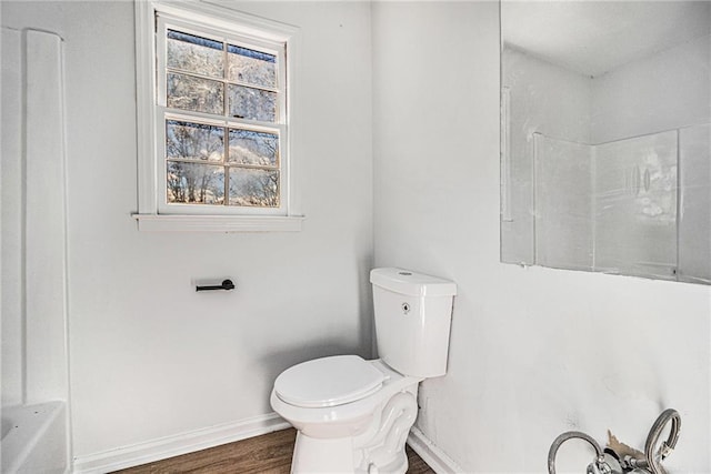 bathroom with baseboards, walk in shower, toilet, and wood finished floors