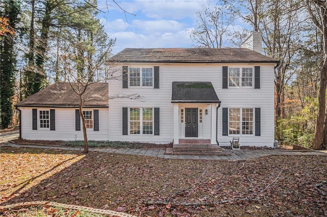 colonial inspired home featuring a chimney