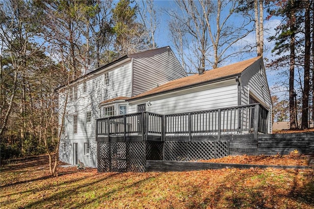 rear view of house featuring a deck and a yard