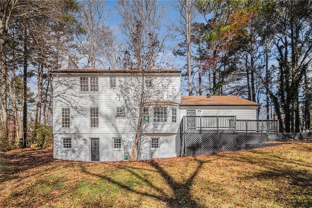 back of house with a deck and a lawn