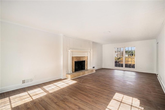 unfurnished living room featuring dark wood-style floors, baseboards, visible vents, and a tiled fireplace