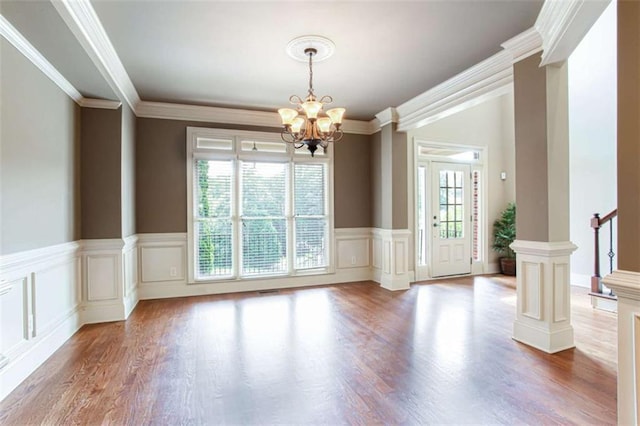240 Chandler Walk, Loganville, GA 30052 - unfurnished room with a chandelier, wood finished floors, ornamental molding, wainscoting, and stairway