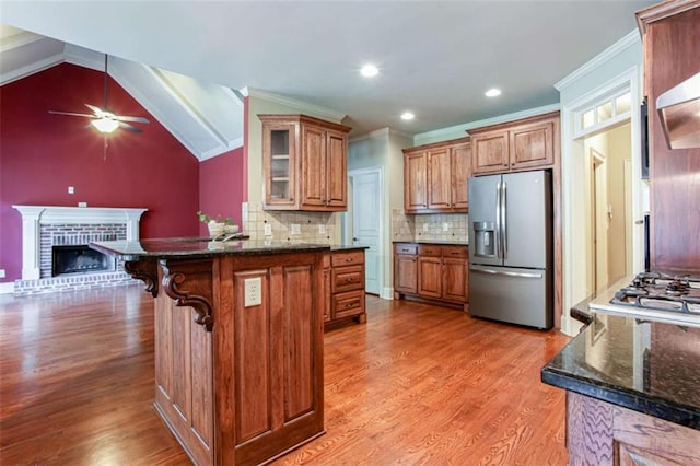 240 Chandler Walk, Loganville, GA 30052 - kitchen featuring stainless steel fridge with ice dispenser, a ceiling fan, brown cabinets, ornamental molding, and tasteful backsplash