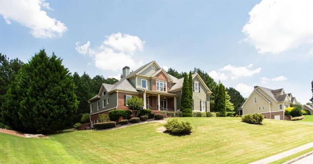 240 Chandler Walk, Loganville, GA 30052 - view of front of home with a front lawn, a chimney, and brick siding