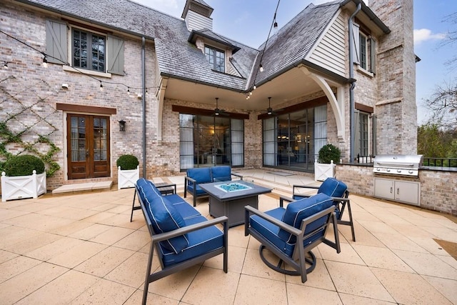 view of patio / terrace featuring an outdoor living space with a fire pit, area for grilling, fence, exterior kitchen, and french doors