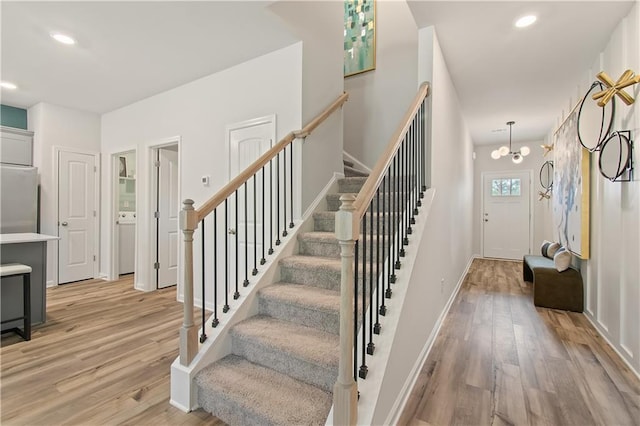 stairway with a notable chandelier and hardwood / wood-style flooring