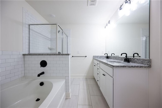 bathroom featuring vanity and independent shower and bath