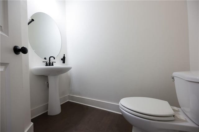 bathroom with hardwood / wood-style flooring and toilet