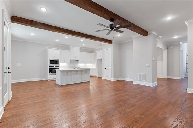 unfurnished living room featuring ceiling fan, crown molding, beamed ceiling, and light wood-type flooring