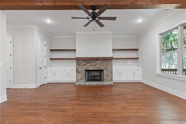 unfurnished living room with ceiling fan, dark hardwood / wood-style floors, ornamental molding, and a fireplace