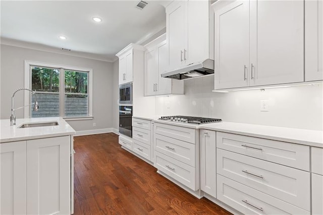 kitchen with sink, crown molding, dark wood-type flooring, appliances with stainless steel finishes, and white cabinets