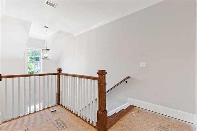 stairs with lofted ceiling and a chandelier