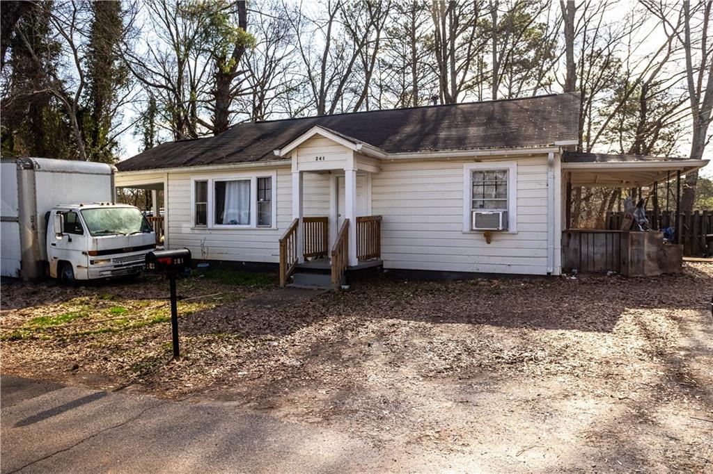 ranch-style house with cooling unit and dirt driveway