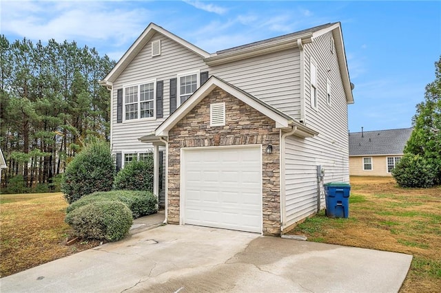 view of home's exterior featuring driveway, stone siding, an attached garage, and a lawn