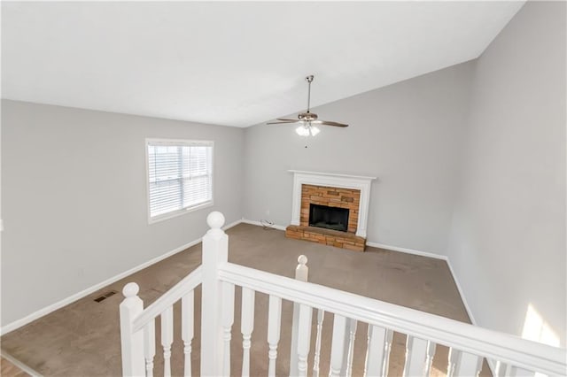 97 Spring Leaf Dr, Dallas, GA 30157 - unfurnished living room with baseboards, vaulted ceiling, a stone fireplace, carpet flooring, and a ceiling fan