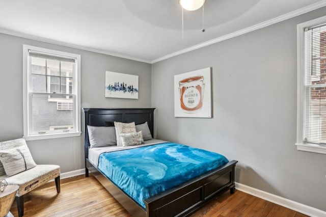 bedroom with hardwood / wood-style flooring, ceiling fan, and crown molding