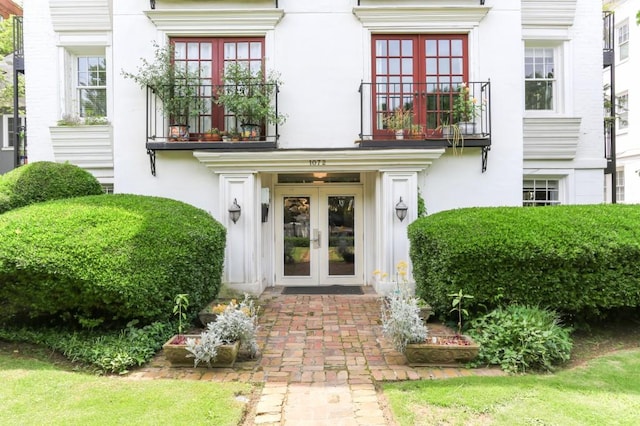 entrance to property featuring a balcony and french doors