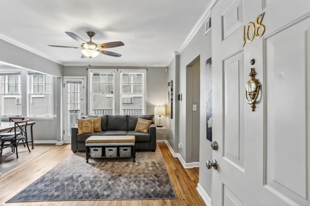 interior space featuring ornamental molding, ceiling fan, and light wood-type flooring