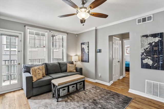 living room with crown molding, hardwood / wood-style floors, and ceiling fan