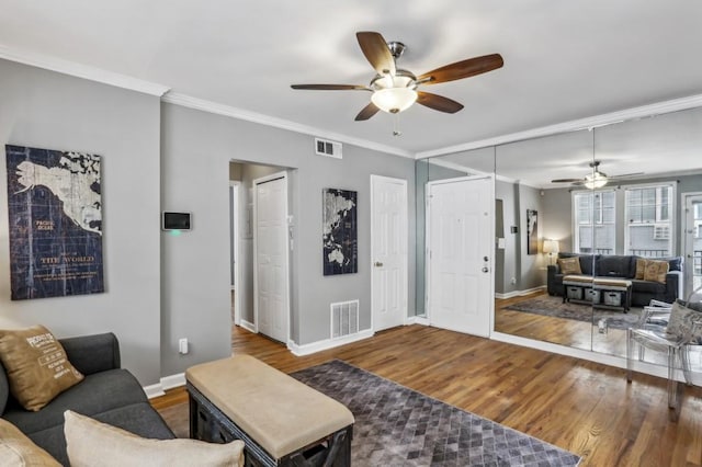 living room featuring crown molding, hardwood / wood-style flooring, and ceiling fan