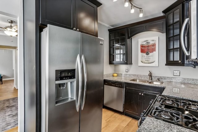 kitchen featuring sink, light hardwood / wood-style flooring, appliances with stainless steel finishes, ceiling fan, and light stone countertops