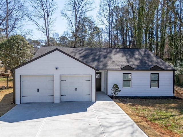 ranch-style house featuring a garage, concrete driveway, and roof with shingles