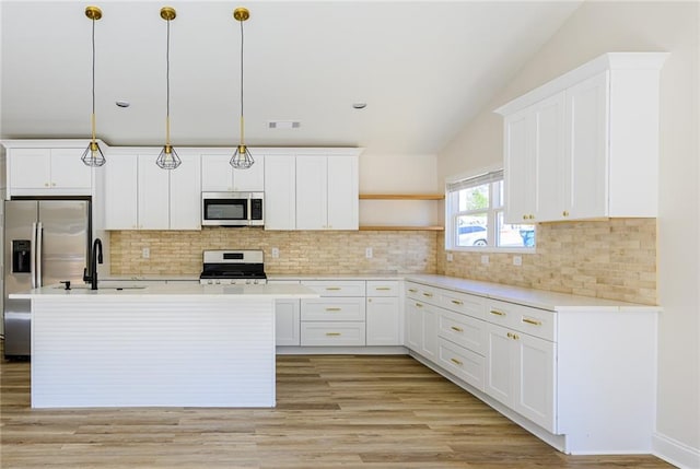 kitchen featuring a sink, light countertops, appliances with stainless steel finishes, backsplash, and open shelves