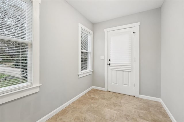 entryway with light tile patterned floors and baseboards