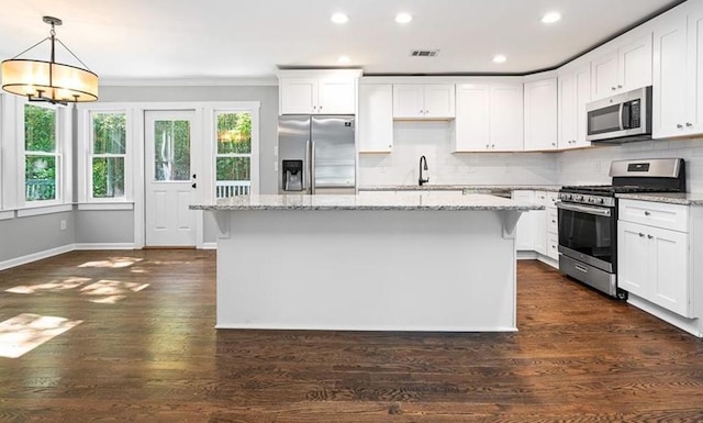 kitchen with a kitchen island, white cabinets, and appliances with stainless steel finishes