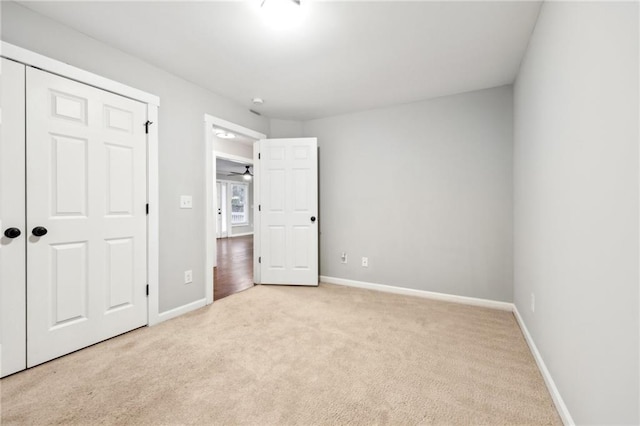 unfurnished bedroom with light carpet and baseboards