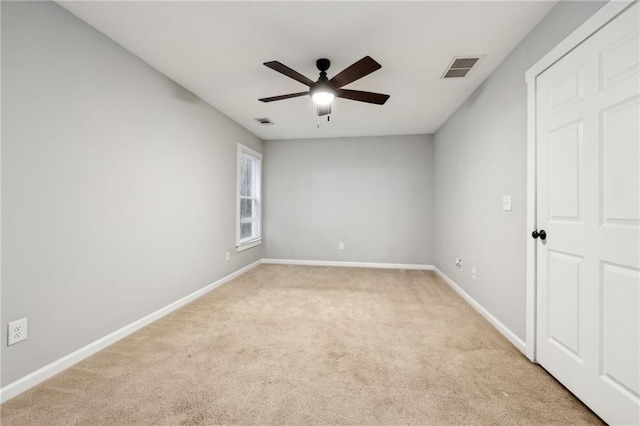 unfurnished room with light carpet, ceiling fan, visible vents, and baseboards