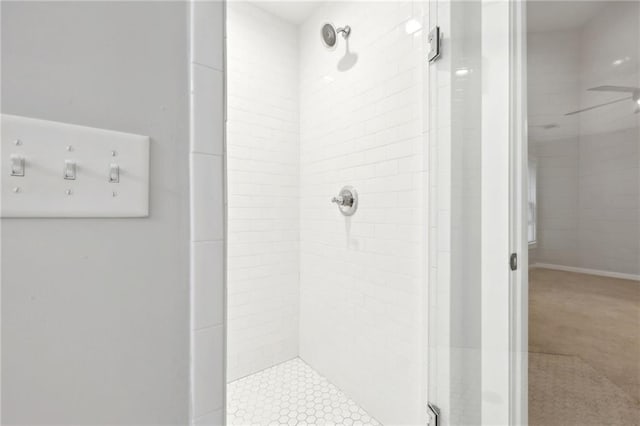 bathroom with a stall shower and a ceiling fan