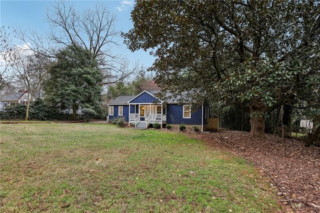 view of front facade featuring covered porch, a front lawn, and board and batten siding