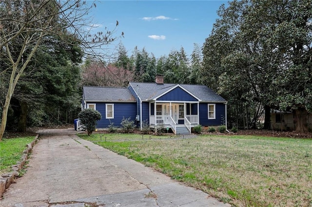 ranch-style home featuring driveway, covered porch, a chimney, and a front lawn