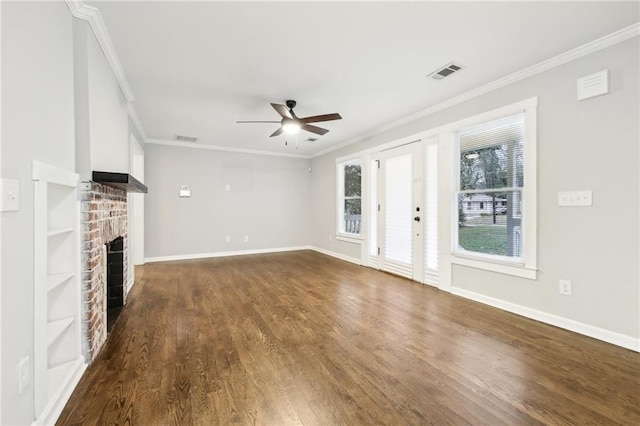 unfurnished living room featuring ornamental molding, dark wood-style flooring, a brick fireplace, and visible vents