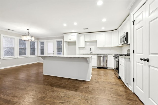 kitchen featuring white cabinets, pendant lighting, stainless steel appliances, and a center island